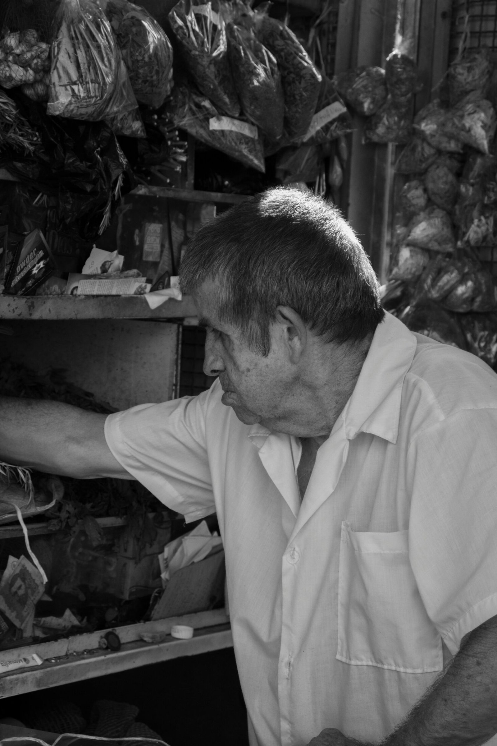 A man standing in front of a shelf filled with meat